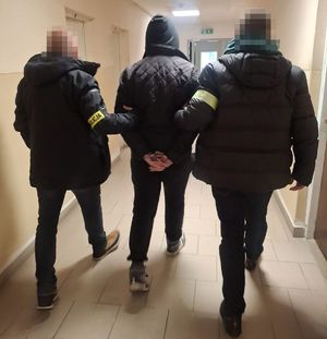 policjanci kryminalni prowadzą zatrzymanego 19-latka