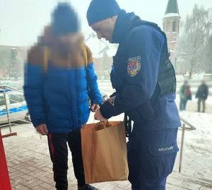 policjant przekazuje zakupy osobie bezdomnej
