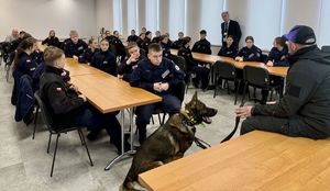 policyjny przewodnik z psem opowiada o pracy uczniom