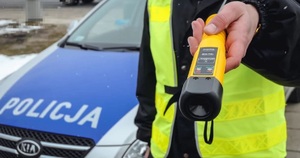 policjant trzymający urządzenie do sprawdzania stanu trzeźwości