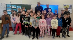 grupa dzieci i dwóch umundurowanych policjantów
