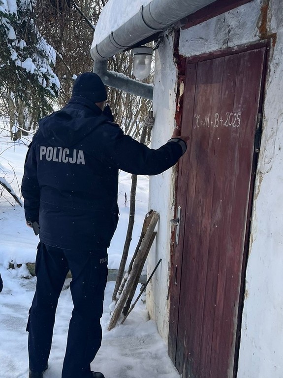 Umundurowany policjant puka do drzwi domu