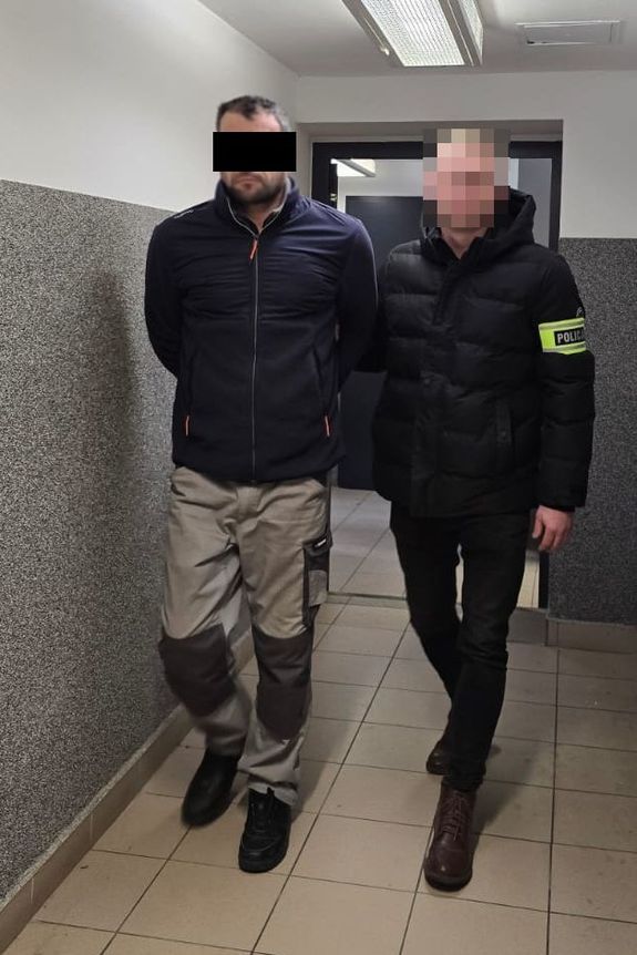 policjant prowadzi zatrzymanego mężczyznę