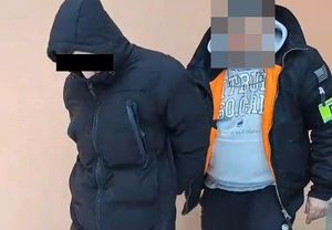 zatrzymany mężczyzna w kajdankach prowadzony przez policjanta