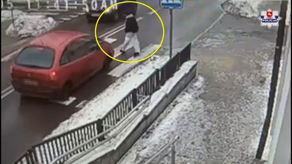 Kobieta przechodzi przez przejście dla pieszych.