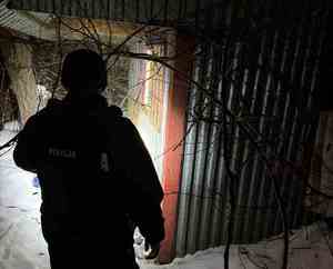 policjant podczas sprawdzania altanek zimą