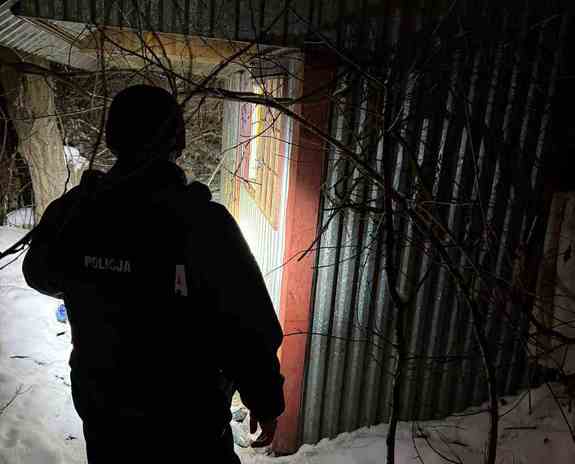 policjant podczas sprawdzania altanek zimą