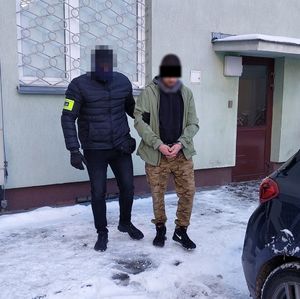 policjant prowadzi zatrzymanego