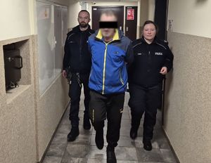 umundurowani policjanci prowadzą podejrzanego