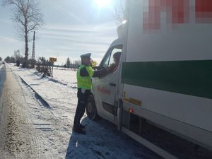 Policjant badający trzeźwość kierującego pojazdem dostawczym.