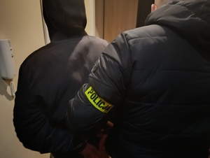 nieumundurowany policjant prowadzi zatrzymanego mężczyznę