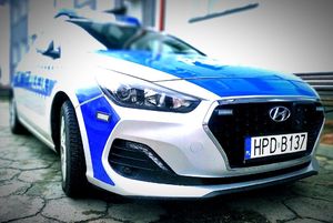 policyjny radiowóz pod budynkiem