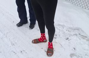 nogi zatrzymanego w skradzionych skarpetach i ciapach oraz nogi policjanta na śniegu