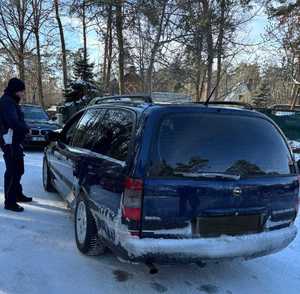 policjant kontroluje zatrzymany pojazd