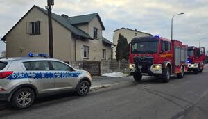 radiowóz i wóz straży pożarnej pod dom, w którym doszło do pożaru