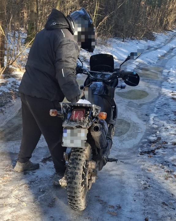 motocyklista stoi przy motocyklu