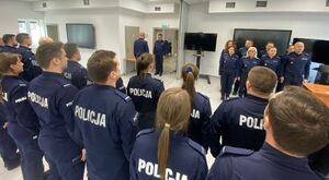 Uroczysta zbiórka policjantów na sali dydaktycznej. Policjanci ustawieni w szeregu są zwróceni frontem do kadry dydaktycznej