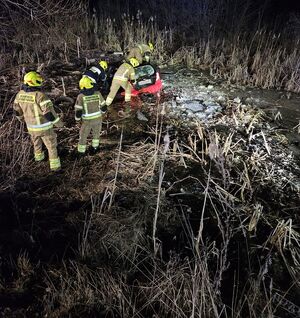 strażacy pracują przy pojeździe, który wpadł do bagna