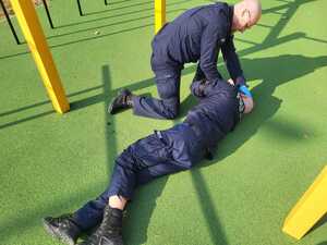 umundurowani policjanci ćwiczą udzielanie pierwszej pomocy