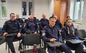 umundurowani policjanci siedzą na krzesłach w sali wykładowej