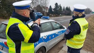 policjanci wydziału ruchu drogowego. Policjant stoi z laserowym miernikiem prędkości