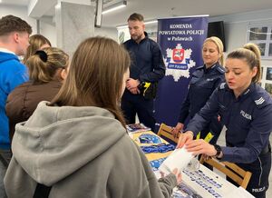 policjanci udzielający informacji młodzieży przy stoisku
