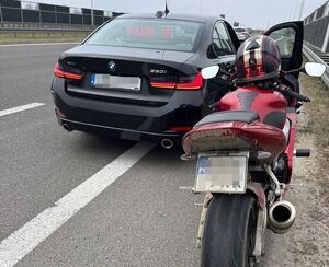 motocykl podczas kontroli drogowej, w tle nieoznakowany radiowóz