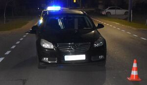 samochód na drodze, w tle radiowóz