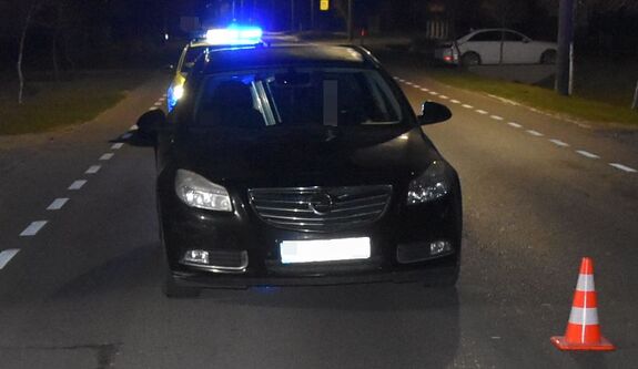 samochód na drodze, w tle radiowóz