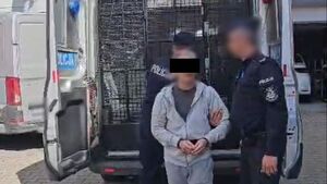 policjant prowadzi zatrzymanego