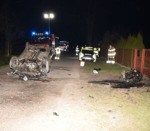 samochód leży na dachu. Obok funkcjonariusze wykonują czynności