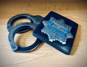 kajdanki i policyjna legitymacja