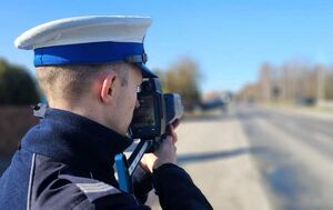 policjant z miernikiem prędkości na drodze