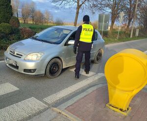 policjant sprawdza trzeźwość osoby kierującej samochodem osobowym