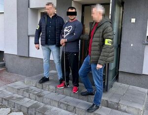 zatrzymany prowadzony przez dwóch nieumundurowanych policjantów