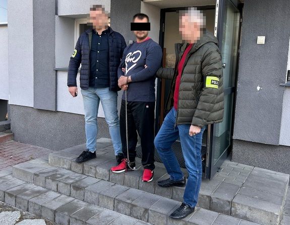 zatrzymany prowadzony przez dwóch nieumundurowanych policjantów