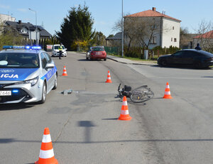 skrzyżowanie dróg, miejsce potrącenia rowerzysty, na ulicy leży rower obok stoi radiowóz