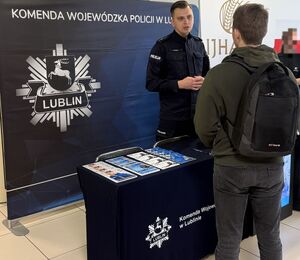 policjant prezentuje stoisko promocyjne podczas Dnia Kariery w Uniwersytecie Przyrodniczym w Lublinie