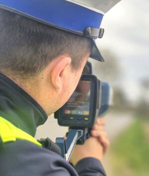 policjant z miernikiem prędkości