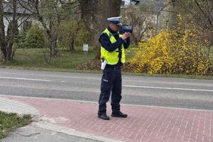 policjant przy drodze z miernikiem prędkości
