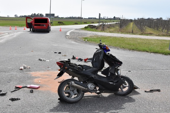 na jezdni stoi motorower, wokół znajdują się drobne elementy rozbitego pojazdu.