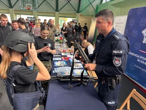 policjant prezentuje stoisko policyjne na targach edukacyjno-zawodowych w Kraśniku