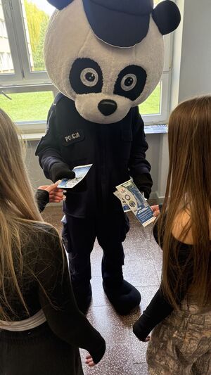 maskotka policji sierżant Poli rozdaje ulotki uczennicom