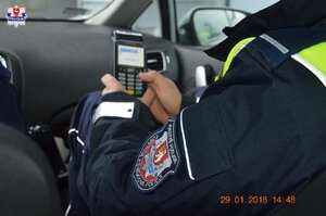 policjant trzyma w ręku terminal