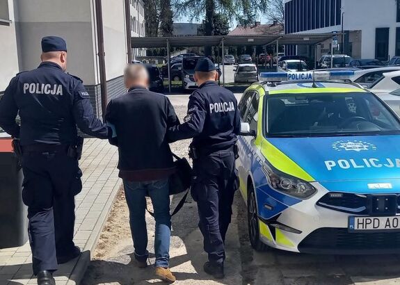 Policjanci prowadzą zatrzymanego