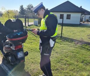 policjant podczas kontroli drogowej kierującego jednośladem