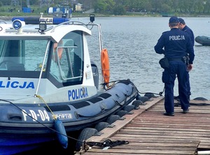 policjanci przy łodzi motorowej