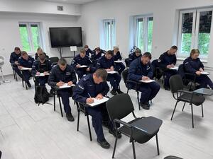 umundurowani policjanci siedzą w ławkach i rozwiązują test