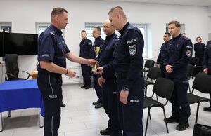 Zastępca Komendanta Wojewódzkiego Policji w Lublinie inspektor Robert Michna wręcza puchar i gratuluje policjantom, którzy zajęli pierwsze miejsce w konkursie