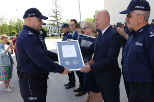 Komendant Wojewódzki Policji w Lublinie insp. Tomasz Gil wręcza pamiątkowy ryngraf Panu Dorianowi Olszewskiemu- Naczelnikowi Wydziału Zaopatrzenia
